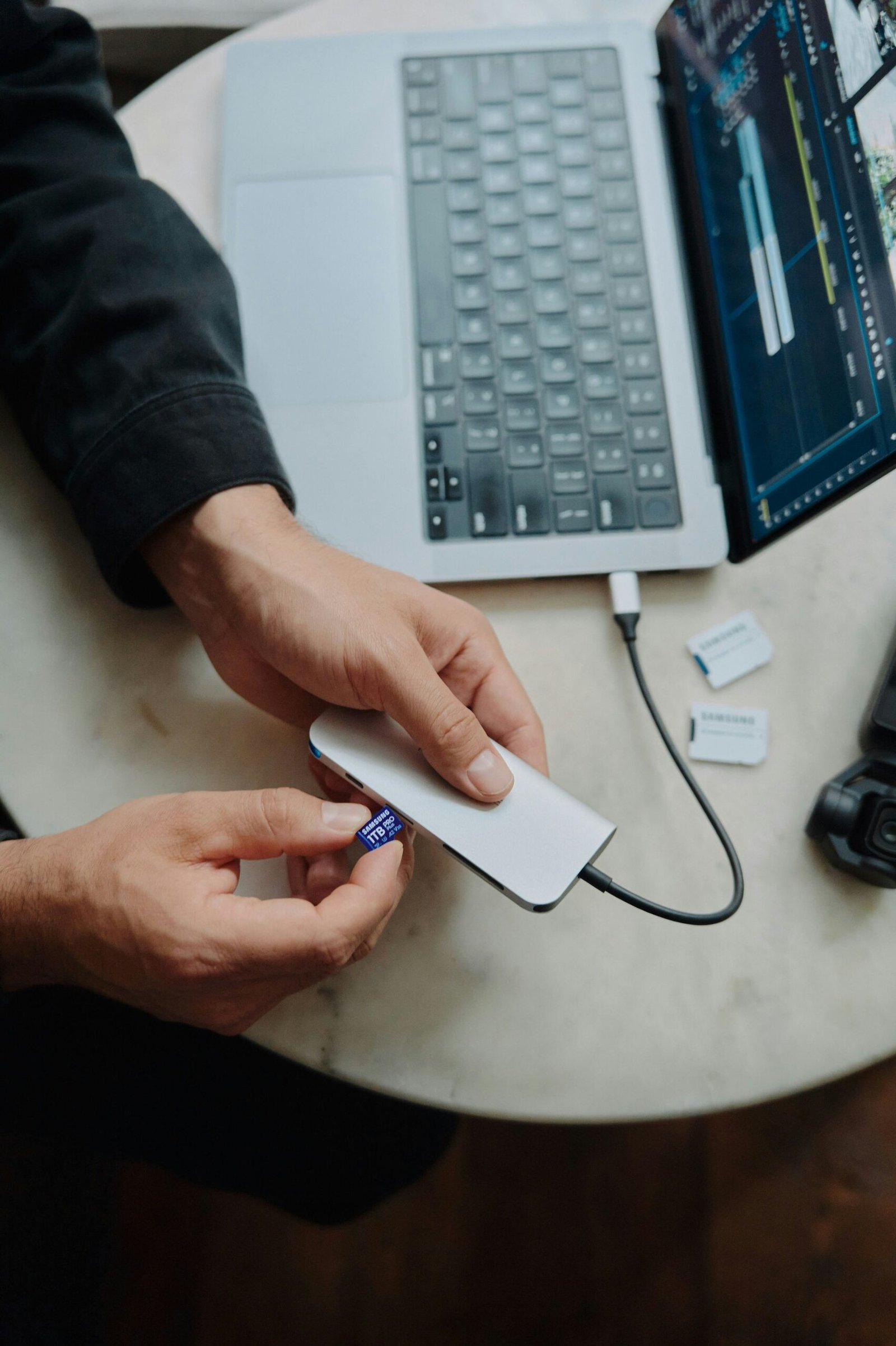 A person sitting at a table with a laptop and a mouse
